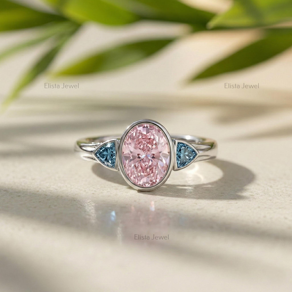 Oval Pink Lab Grown Diamond Three Stone Bezel Set Engagement Ring With Accent Trillions