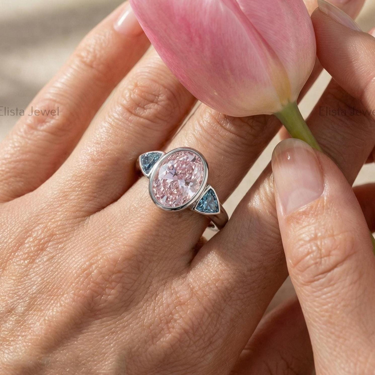 Oval Pink Lab Grown Diamond Three Stone Bezel Set Engagement Ring With Accent Trillions