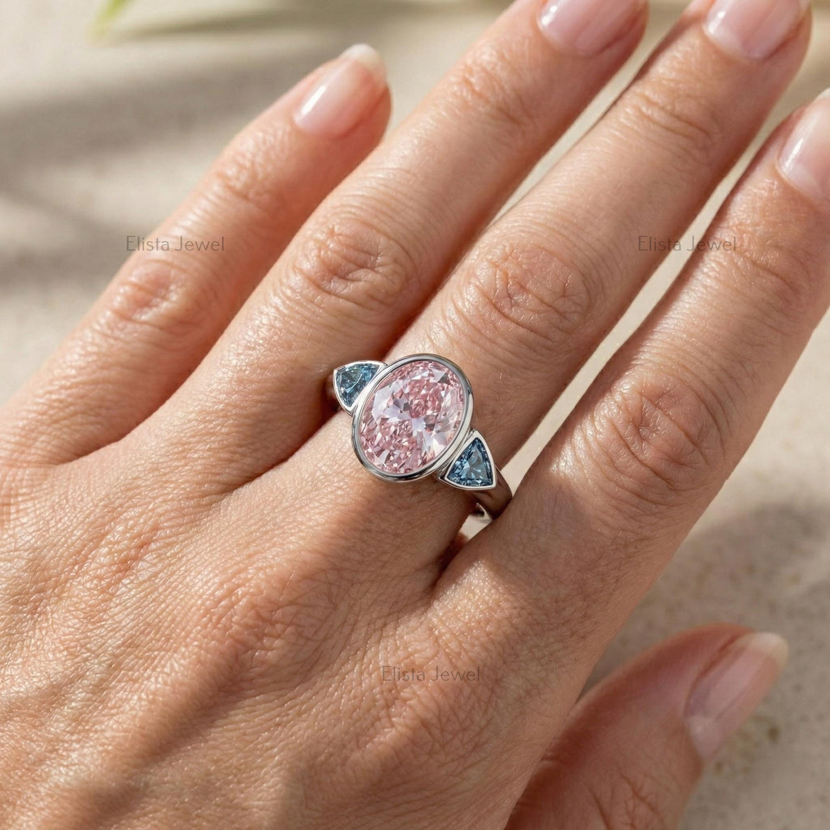 Oval Pink Lab Grown Diamond Three Stone Bezel Set Engagement Ring With Accent Trillions