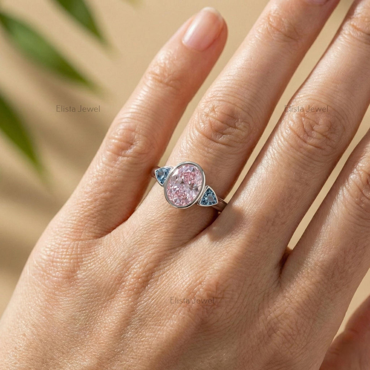 Oval Pink Lab Grown Diamond Three Stone Bezel Set Engagement Ring With Accent Trillions
