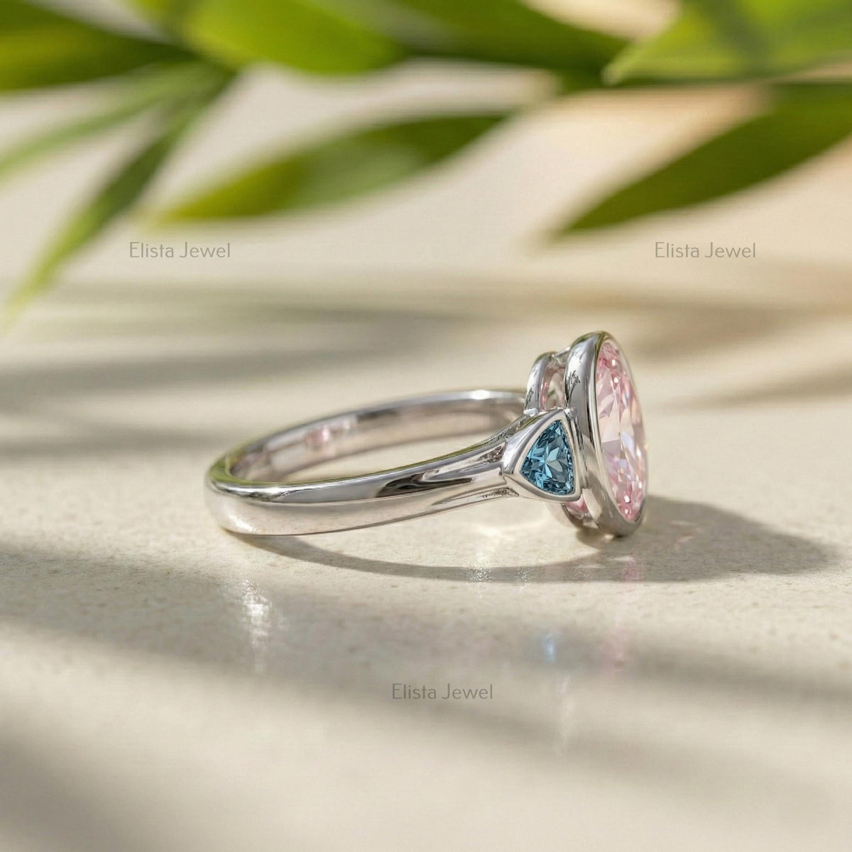 Oval Pink Lab Grown Diamond Three Stone Bezel Set Engagement Ring With Accent Trillions