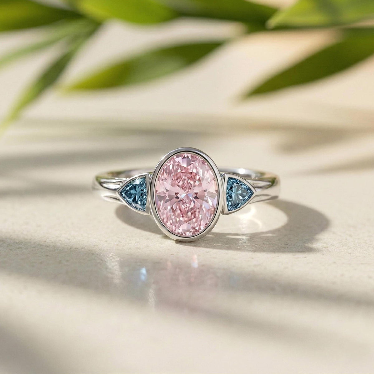 Oval Pink Lab Grown Diamond Three Stone Bezel Set Engagement Ring With Accent Trillions