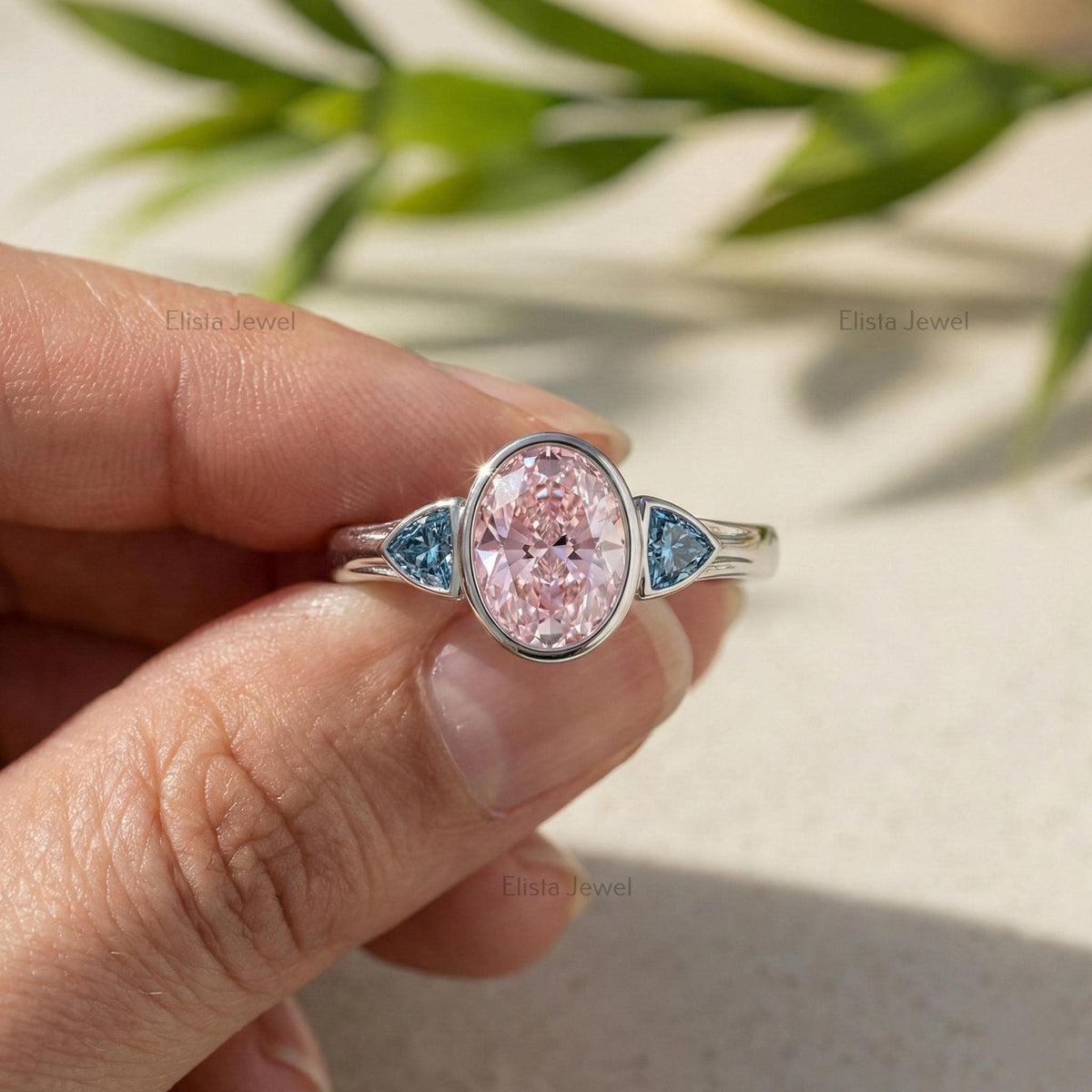 Oval Pink Lab Grown Diamond Three Stone Bezel Set Engagement Ring With Accent Trillions